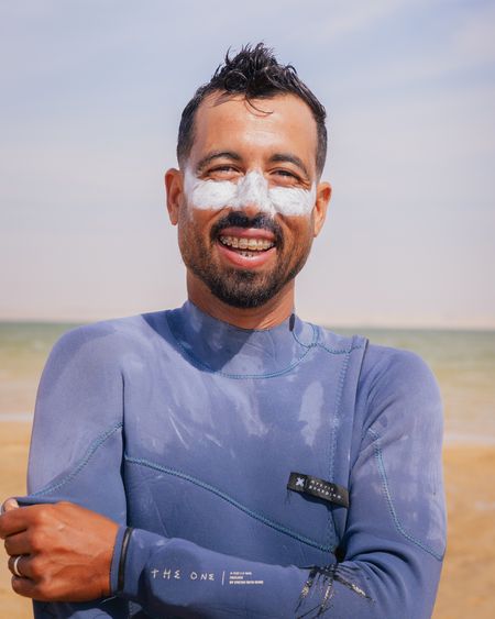 Yassine, founder and head instructor, smiling at the lagoon