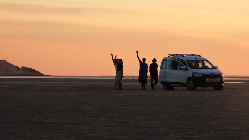 The school van at the water's edge with kites and boards